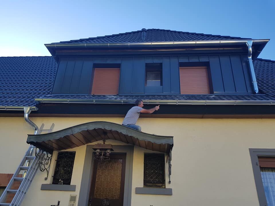 Wohnhaus mit dunklem Dach und mehreren Dachgauben
