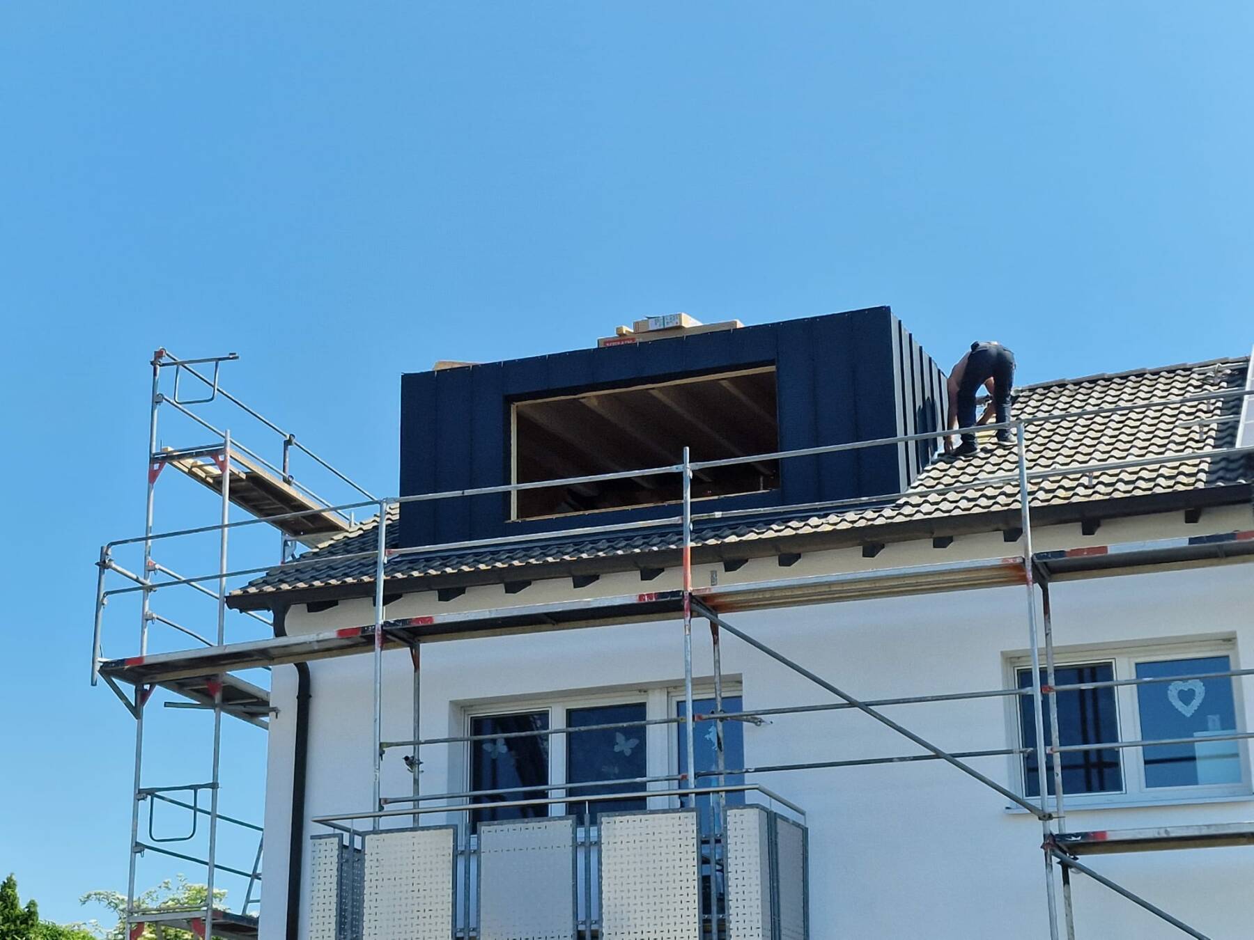 Gebäude mit montierter Solaranlage und Gerüst an der Fassade