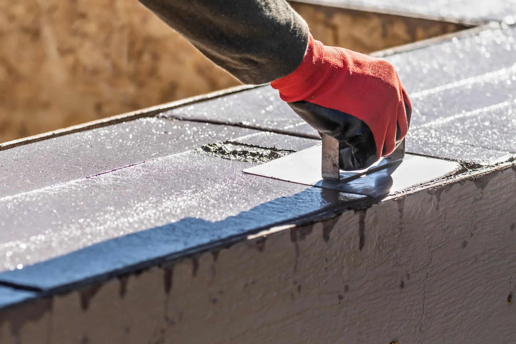 Handwerker bearbeitet frischen Beton mit einem Handwerkzeug