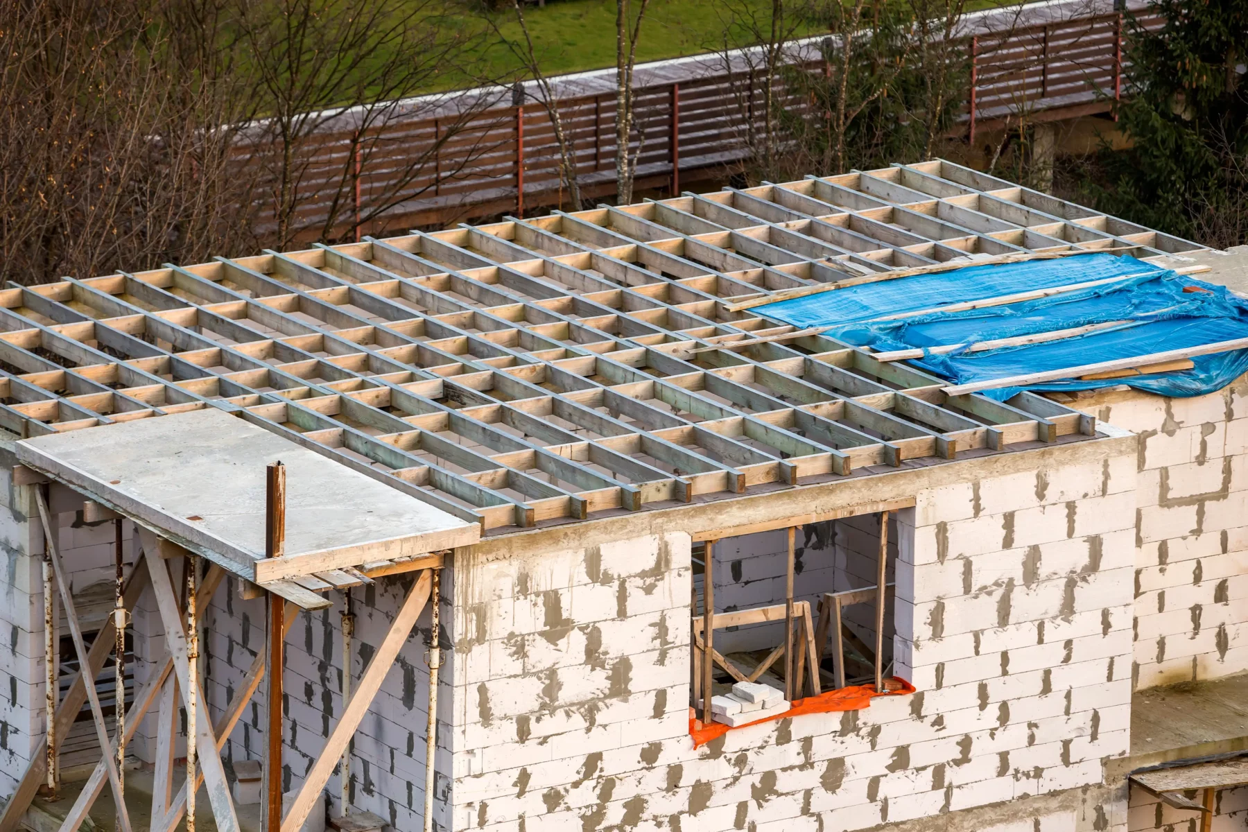 Dachkonstruktion eines Gebäudes im Rohbau mit Holzbalken