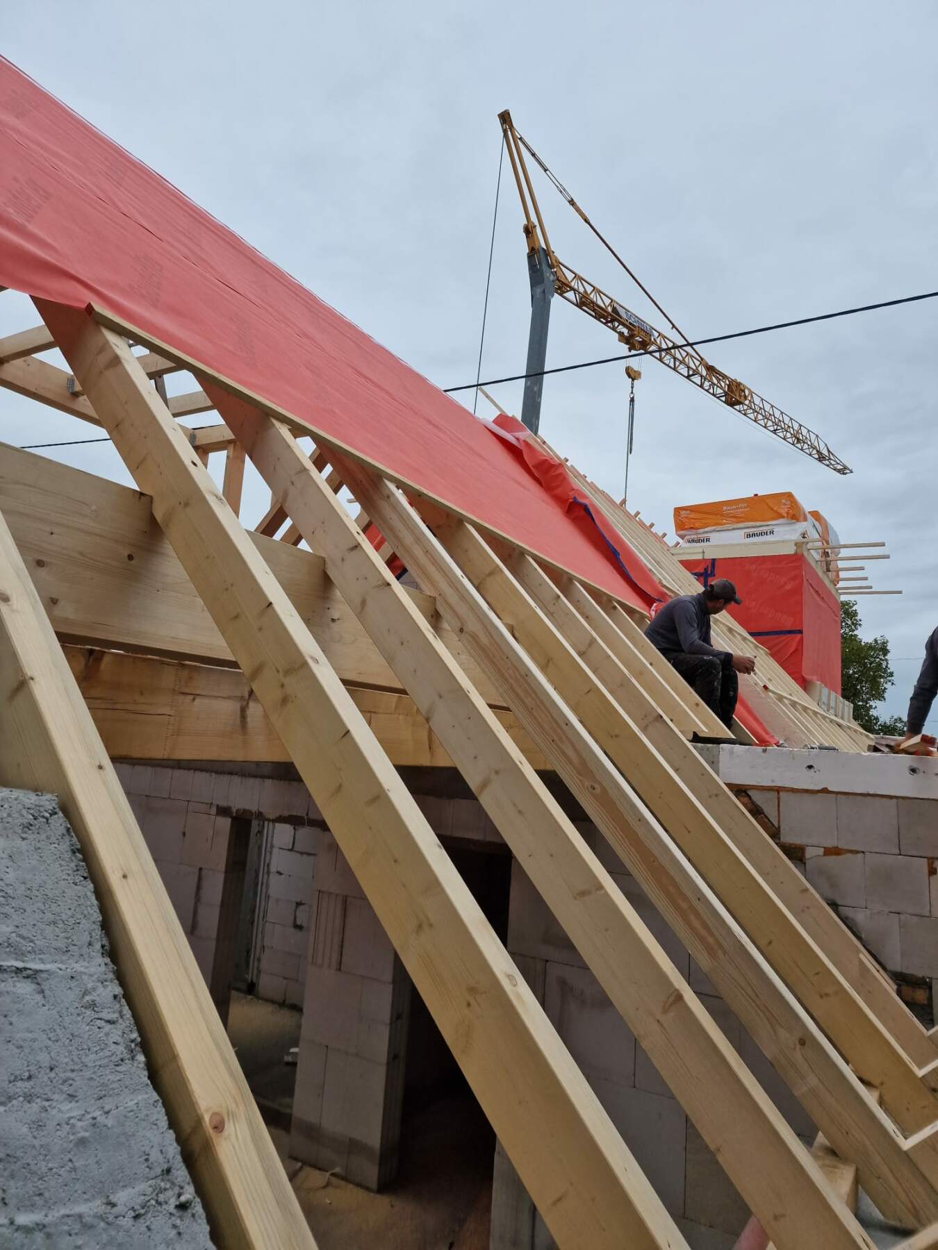 Holzrahmenbau und Dachstuhlmontage mit Kran auf der Baustelle