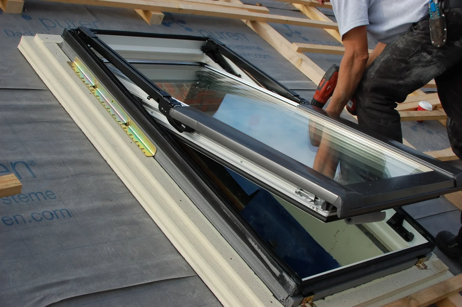 Handwerker beim Einbau eines Dachfensters auf einem Schrägdach