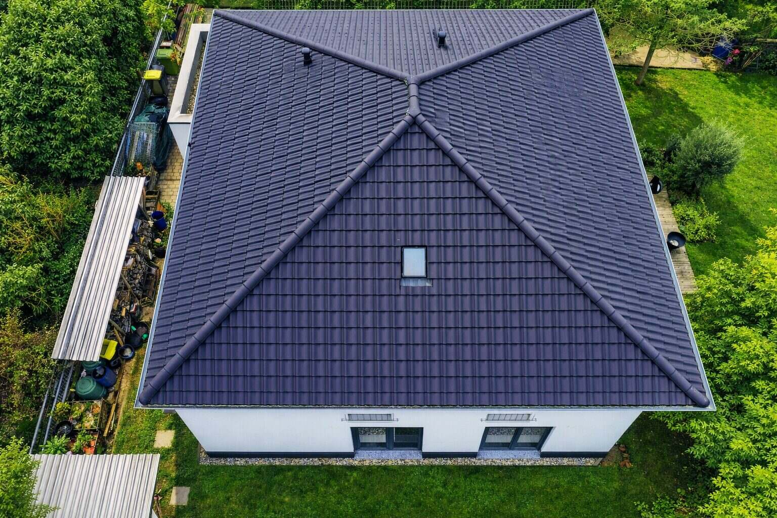 Einfamilienhaus mit dunklem Walmdach aus der Vogelperspektive