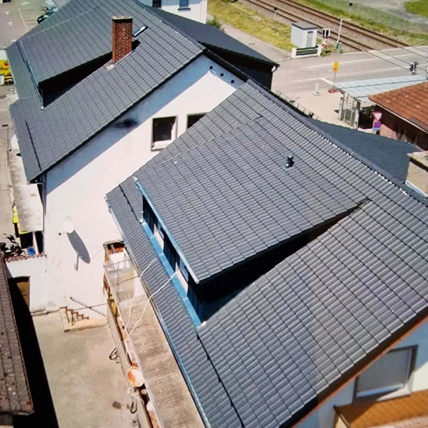 Luftaufnahme eines Hauses mit dunklem Dach und sauberer Dacheindeckung