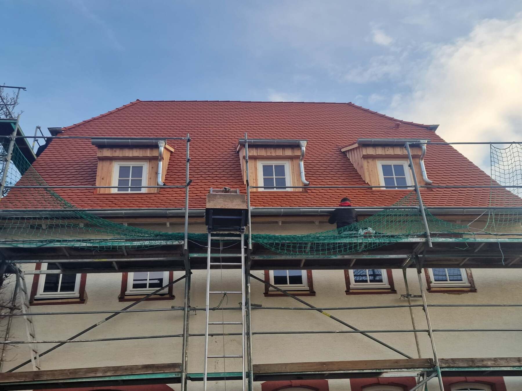 Reihenhaus mit rotem Ziegeldach und Gerüst davor