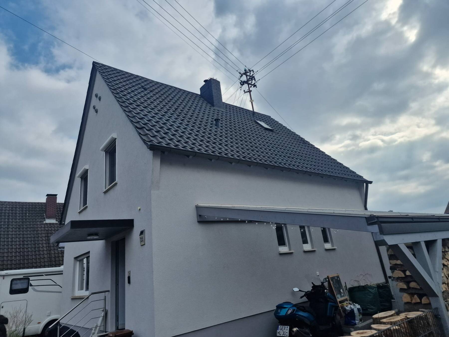 Weißes Einfamilienhaus mit dunklem Schrägdach