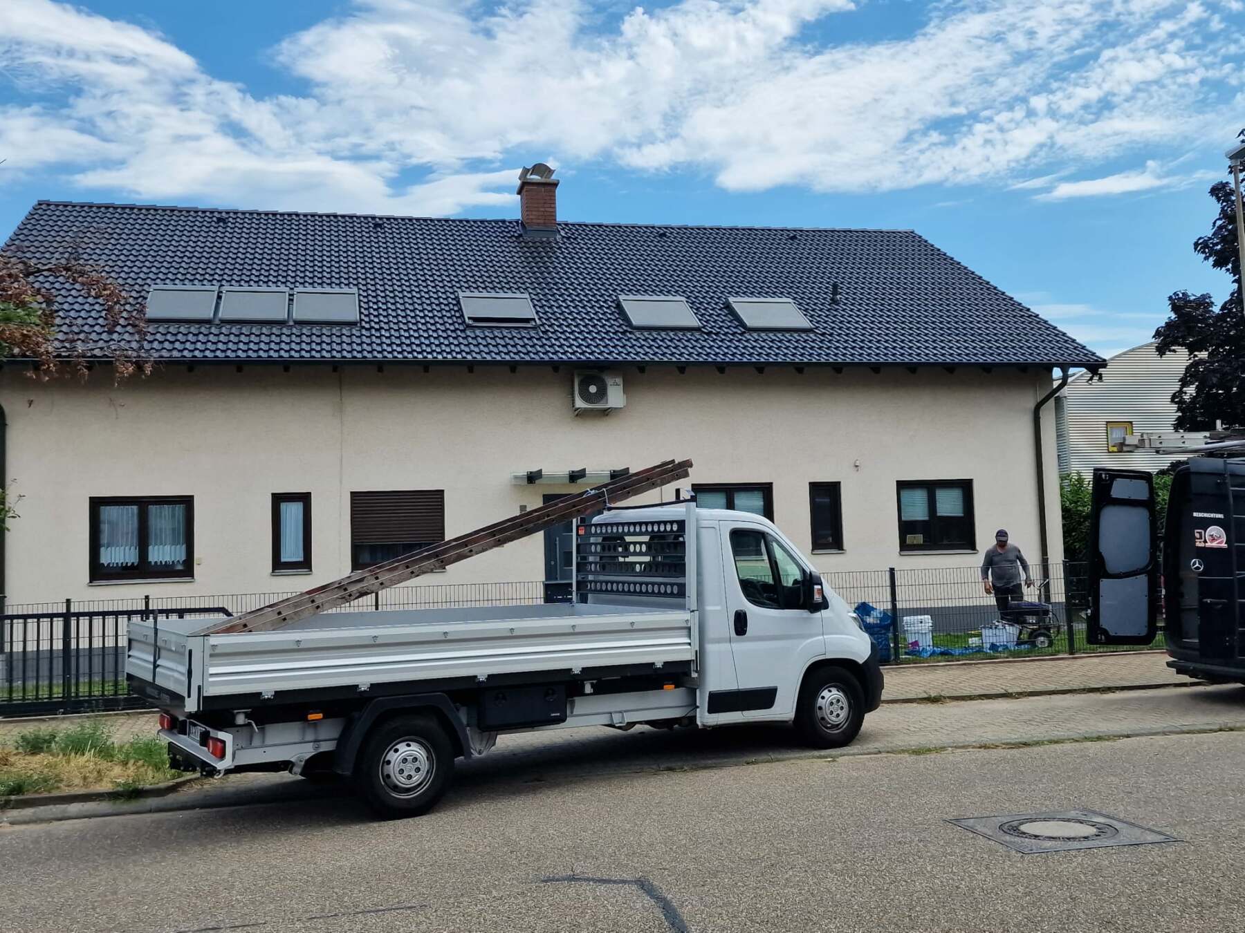 Wohnhaus mit neu eingedecktem Dach und Fahrzeug davor